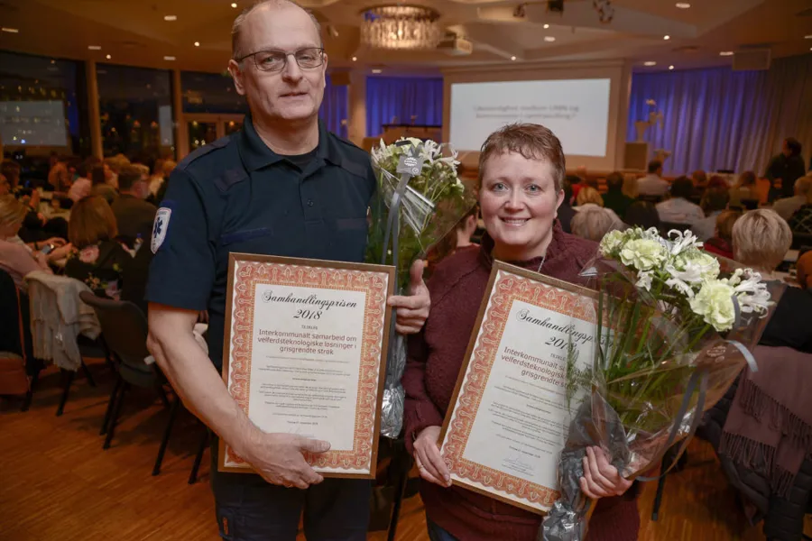 En person som holder et trofé og en person som holder et trofé