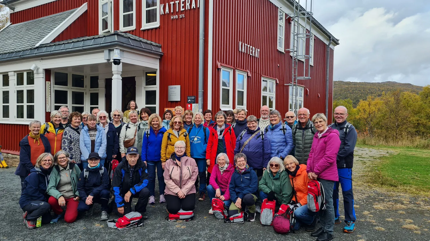 En gruppe mennesker som poserer for et bilde foran en bygning