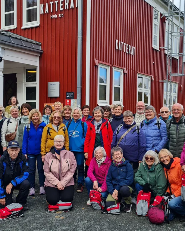 En gruppe mennesker som poserer for et bilde foran en bygning