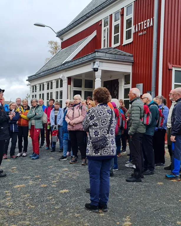 En gruppe mennesker som står utenfor en bygning