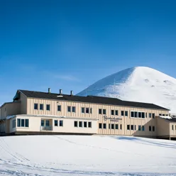 En bygning med et snødekt fjell i bakgrunnen