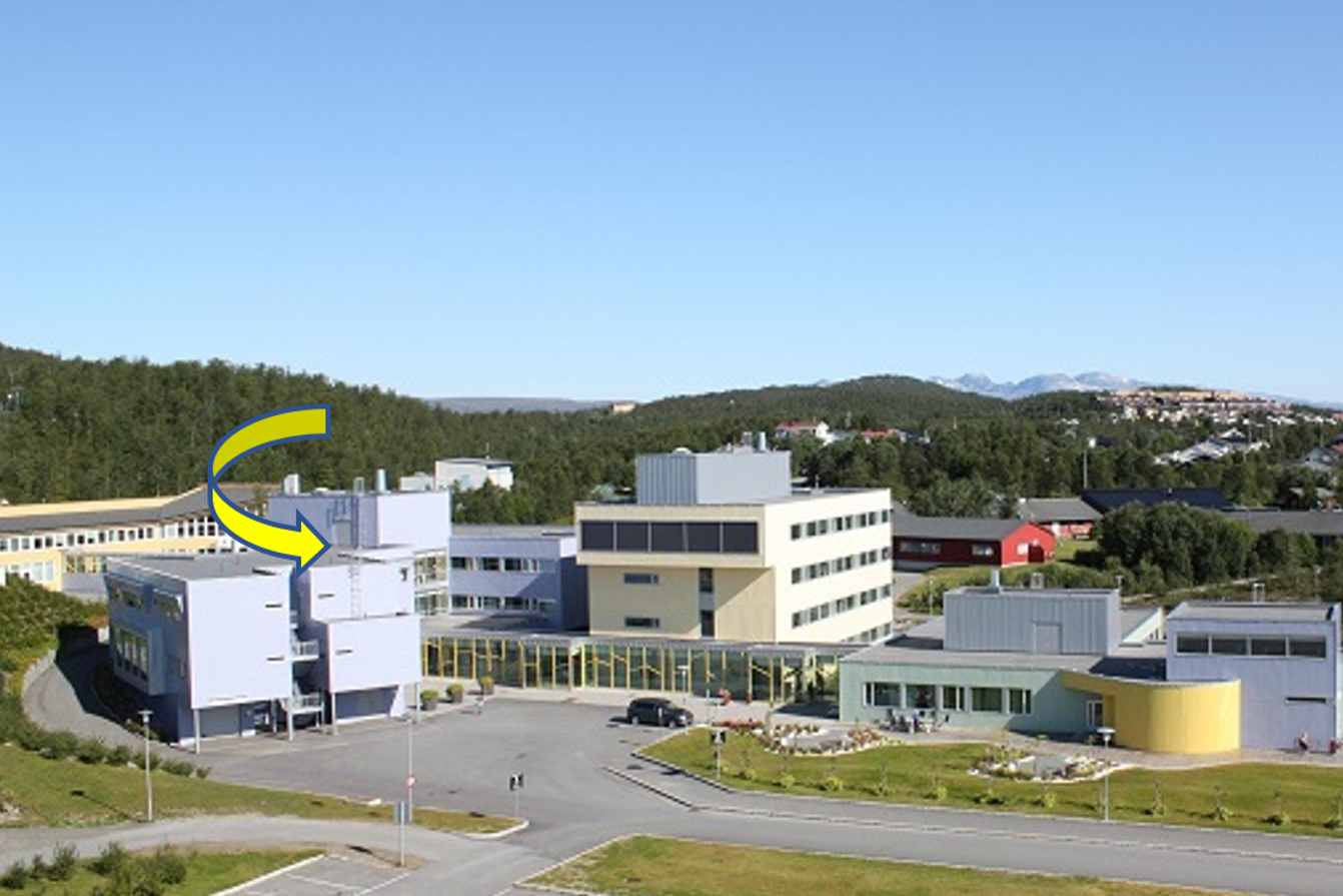 En gruppe bygninger med trær i bakgrunnen