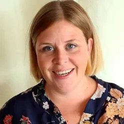 En kvinne som smiler til kameraet